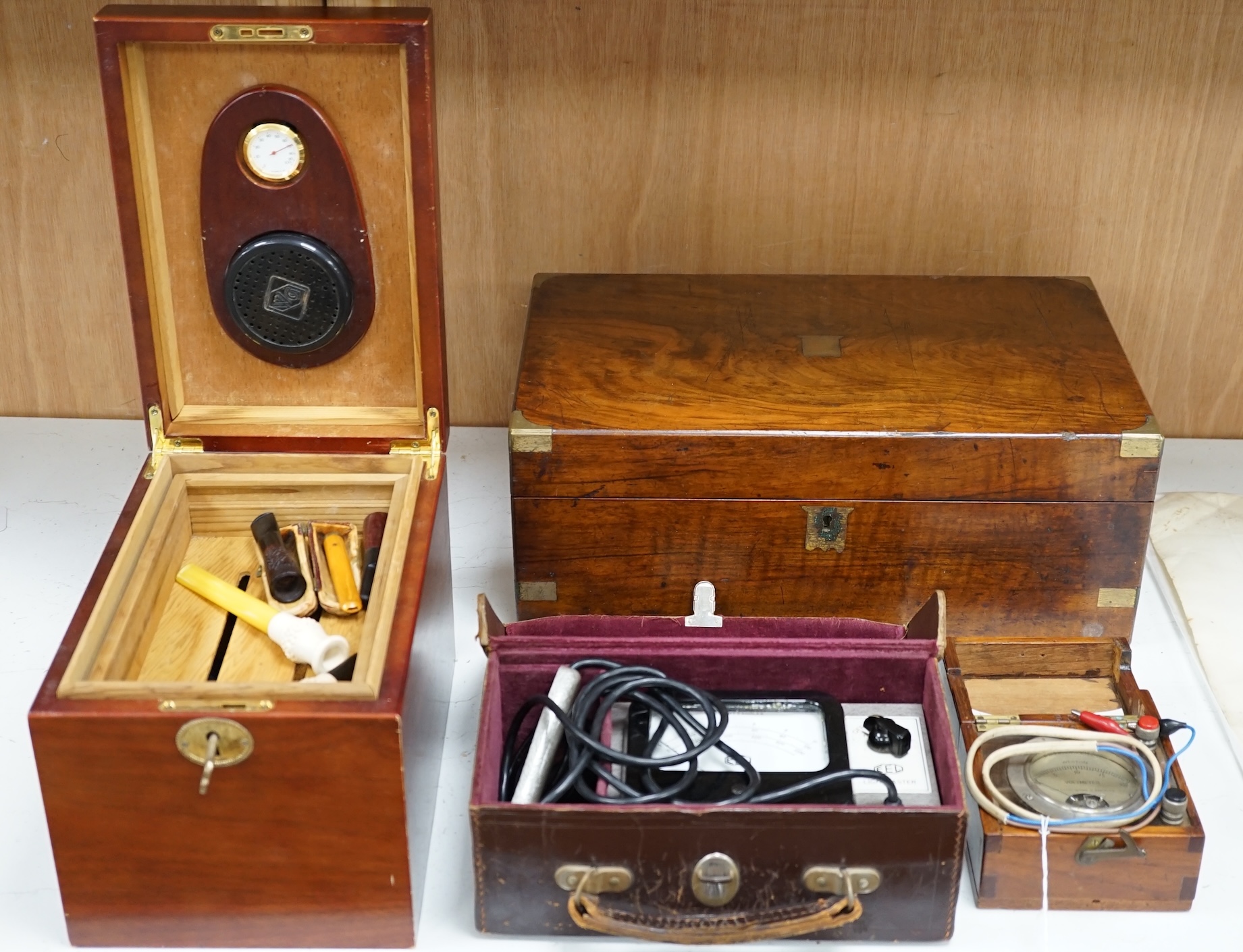 A writing slope, humidor and contents including a silver mounted cigar case, an Evans Electroselenium Ltd. light meter and a Weston Voltmeter. Condition - fair.